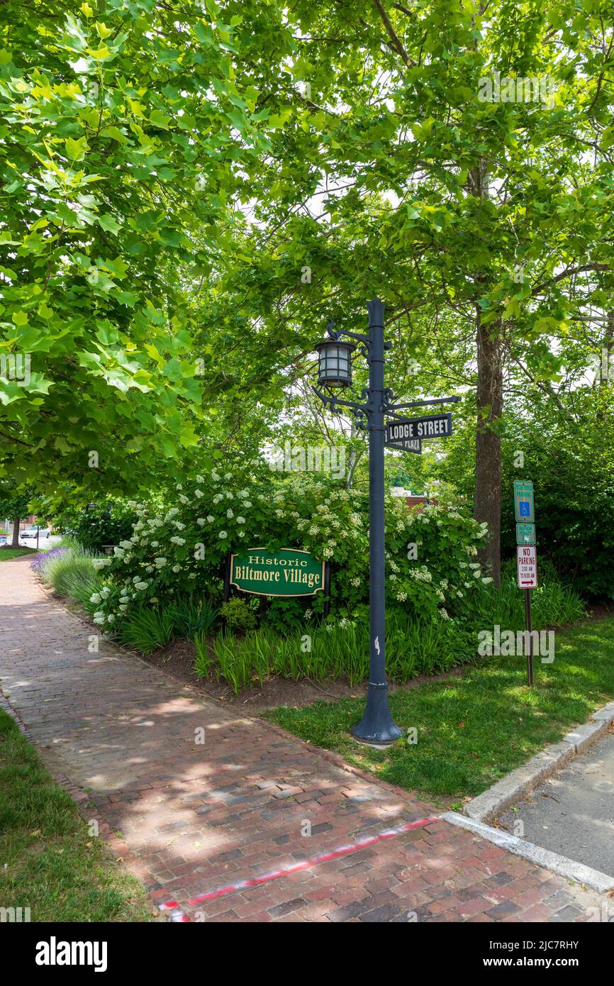 BILTMORE PUEBLO en ASHEVILLE, NC, EE.UU.-5 JUNIO 2022: Señal que identifica 'Historic Biltmore Village, rodeado de follaje. Señales de la calle en el poste de la lámpara. Foto de stock