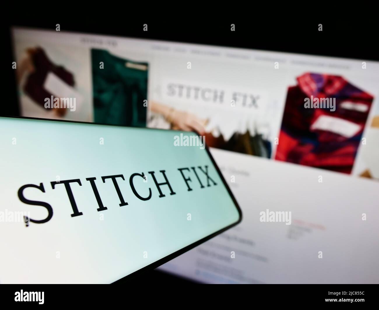 Smartphone con el logotipo de la empresa de estilos americana Stitch Fix Inc. En la pantalla frente al sitio web de la empresa. Enfoque en la parte central izquierda de la pantalla del teléfono. Foto de stock