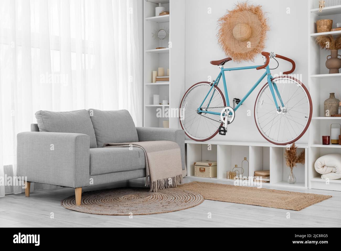 Interior de una moderna sala de estar con bicicleta, estantería y sofá  Fotografía de stock - Alamy