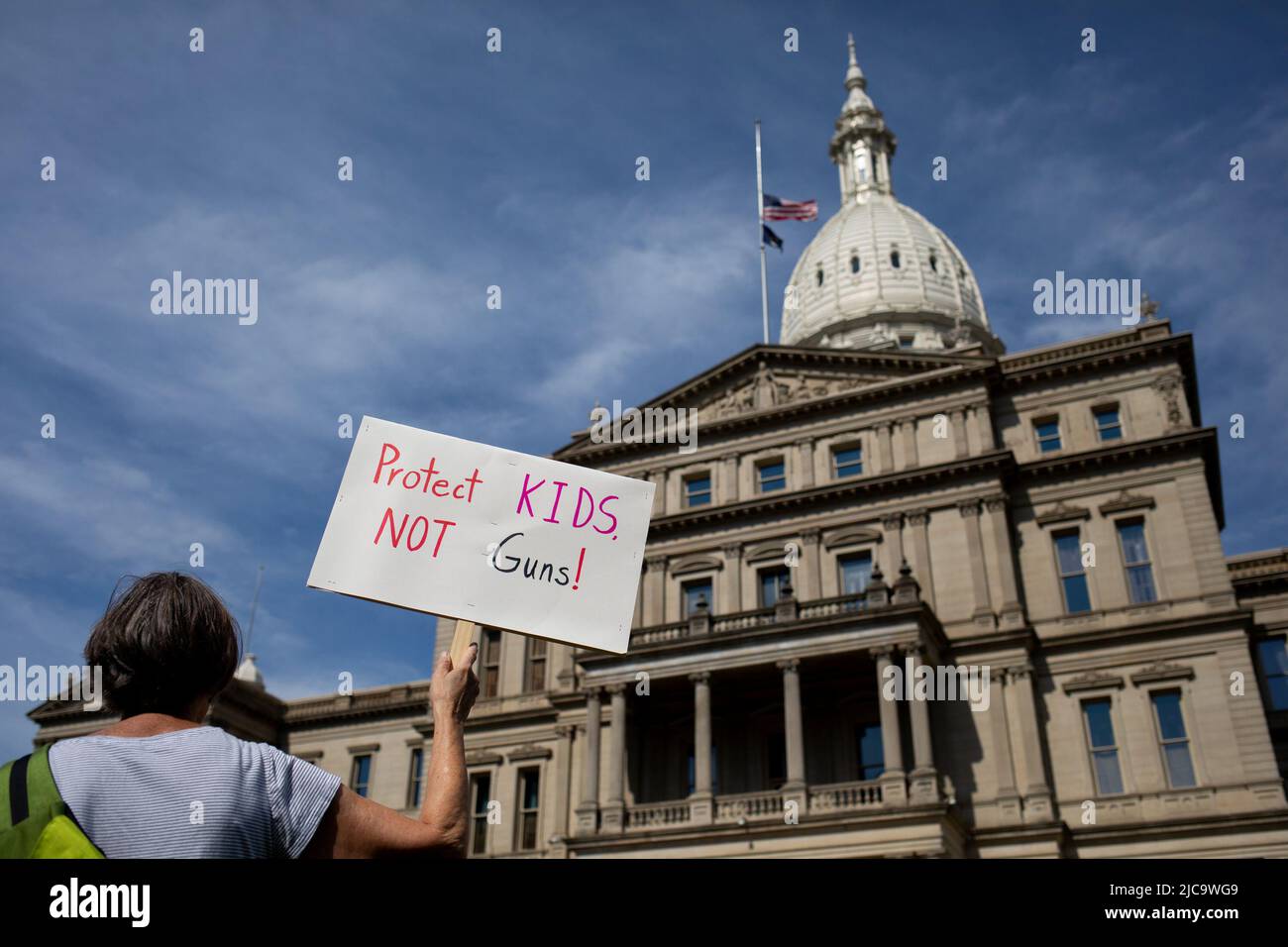 Un participante tiene un cartel fuera del Capitolio del Estado de Michigan durante una manifestación de marcha por nuestras vidas para el control de armas en Lansing, Michigan, EE.UU., 11 de junio de 2022. REUTERS/Emily Elconin Foto de stock