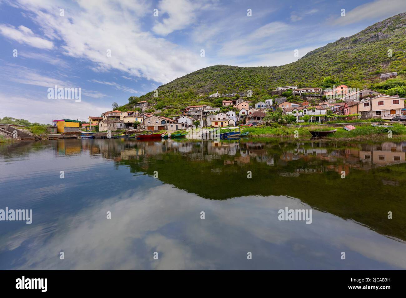 Pueblo pesquero con el reflejo de las casas en el lago Shkoder, Montenegro Foto de stock