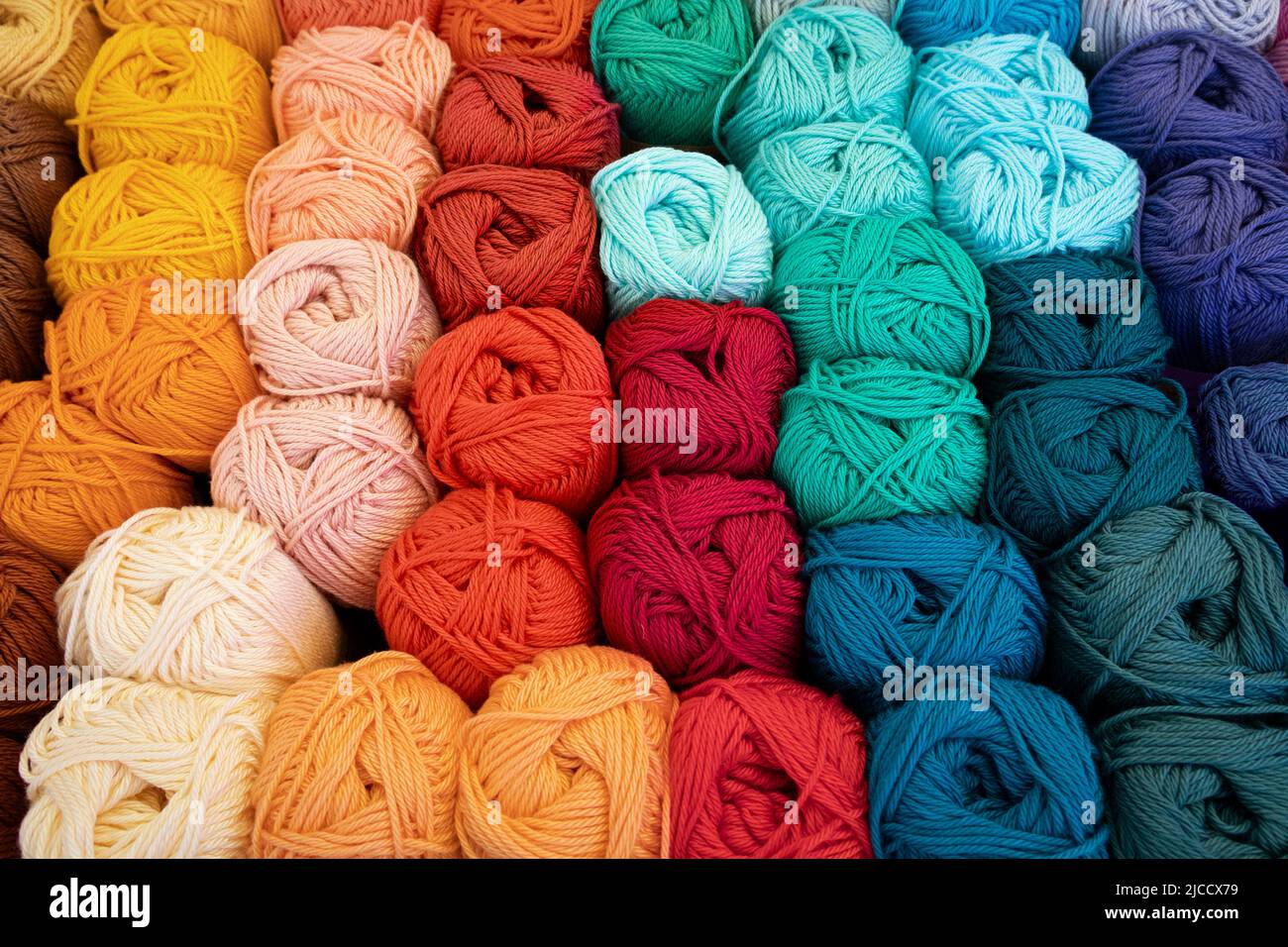 Variación colorida de bolas de lana tejida, nudos de lana, primer plano marco completo como fondo Foto de stock