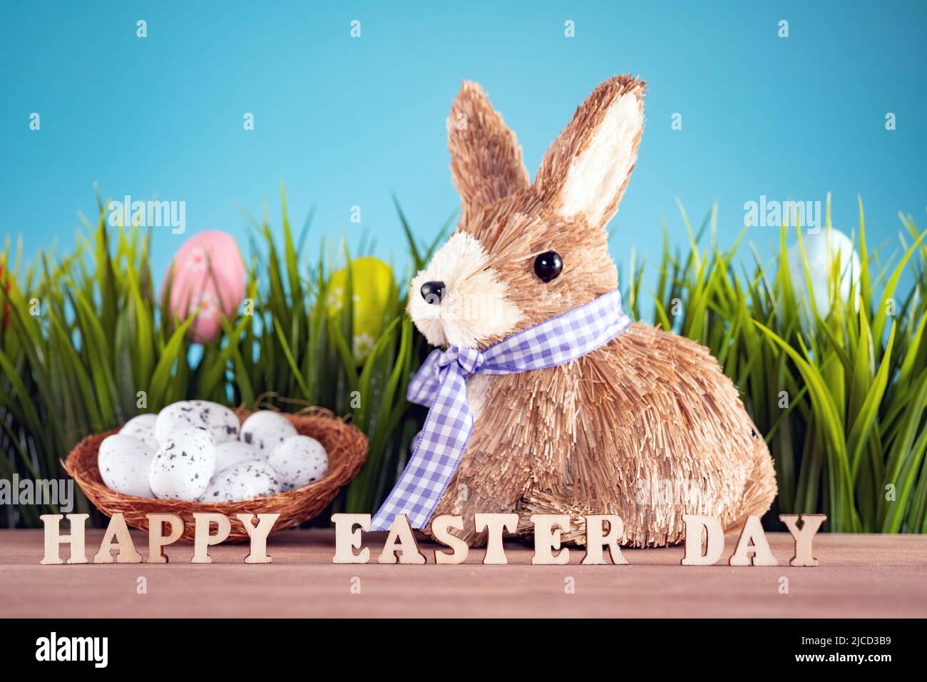 Los huevos de Pascua y lindo bunny sobre mesa de madera con hierba verde. Decoración Navideña Foto de stock