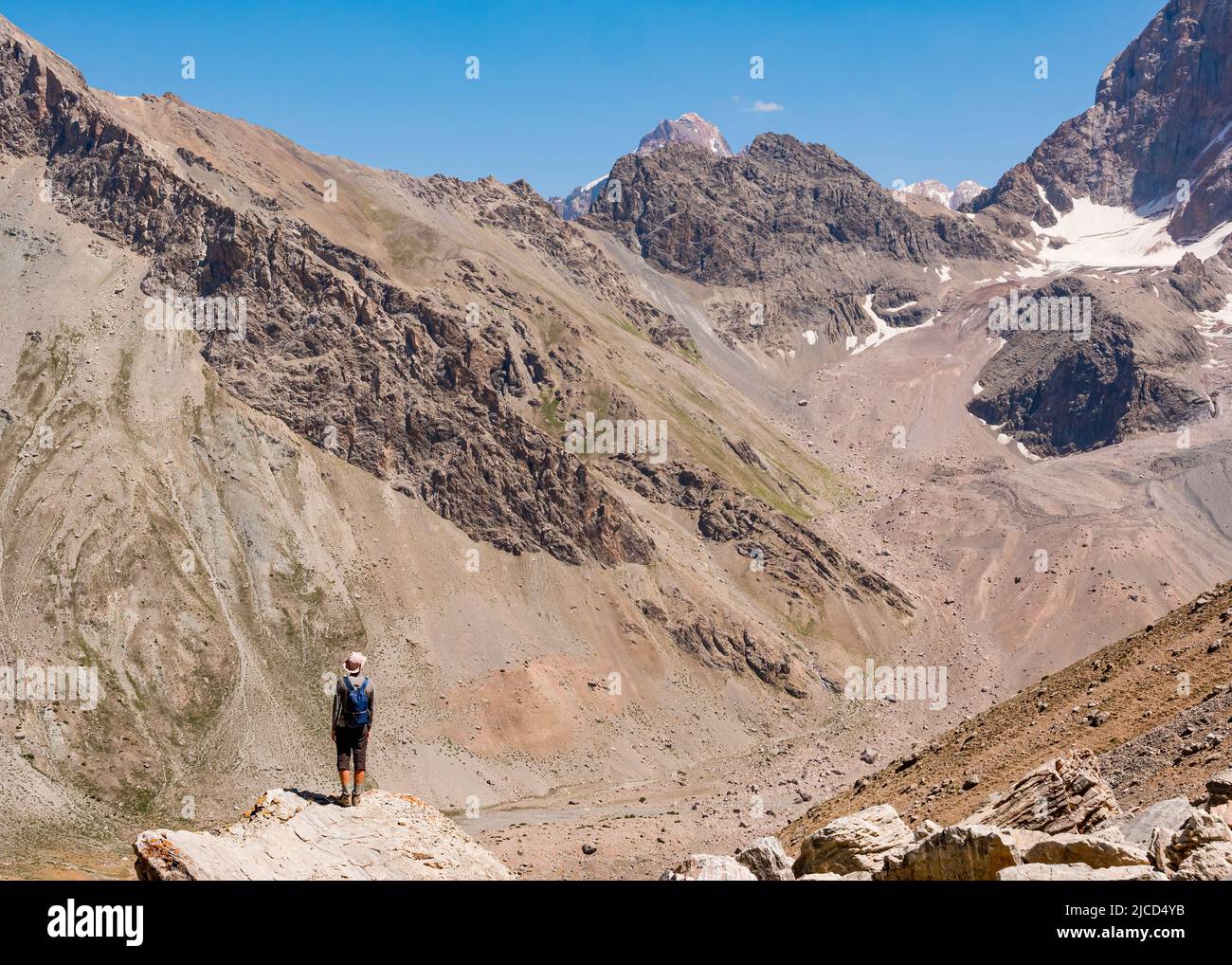 Excursionista sobre fondo rocoso de montaña. Montañas Fann, Tayikistán, Asia Central Foto de stock