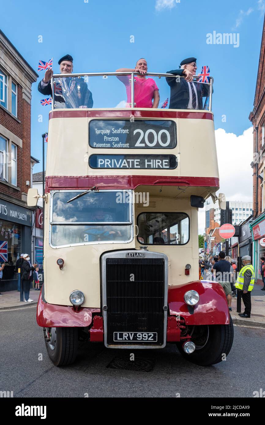 Un autobús de techo abierto con veteranos de Normandía a bordo (ex militares) en el Grand Parade en el evento del Día de Victoria en Aldershot, Hampshire, Inglaterra, Reino Unido Foto de stock