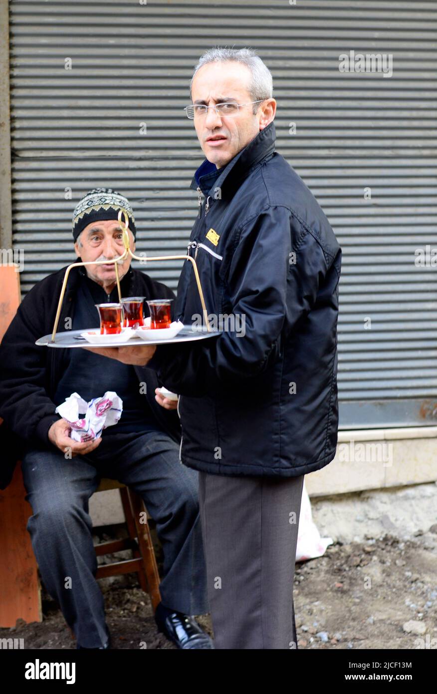 Un hombre turco sirve té en una pequeña tienda de té en Estambul, Turquía. Foto de stock