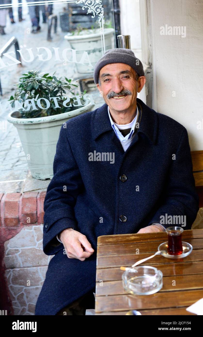 Un hombre turco bebiendo un vaso de té turco en Estambul, Turquía. Foto de stock
