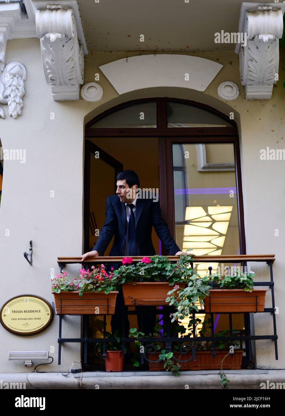 Un hombre turco mirando a la calle desde el balcón. Estambul, Turquía. Foto de stock