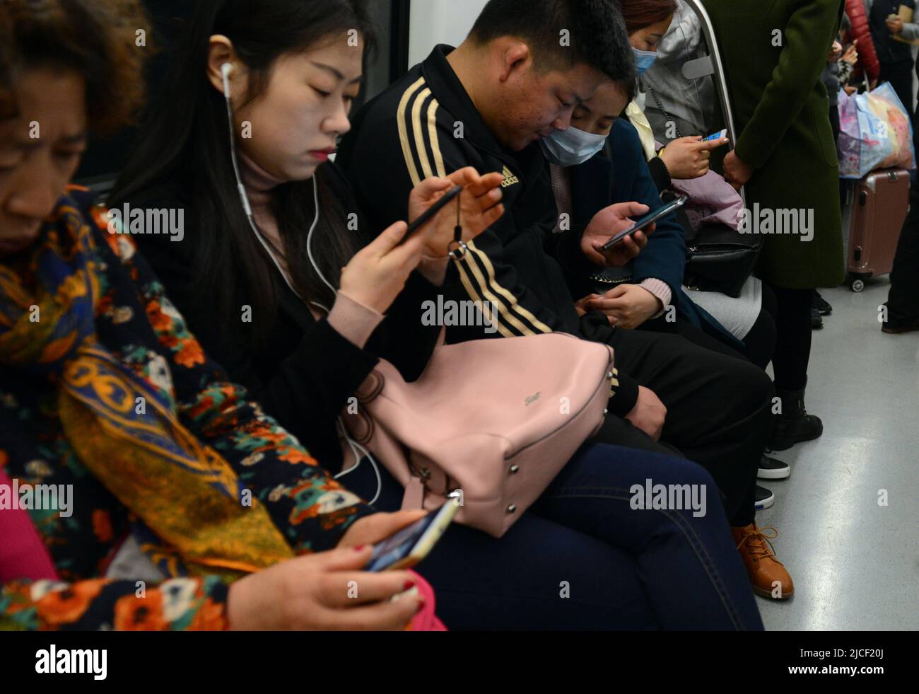 Locales que utilizan sus smartphones en el metro t rain en Nanjing, China. Foto de stock