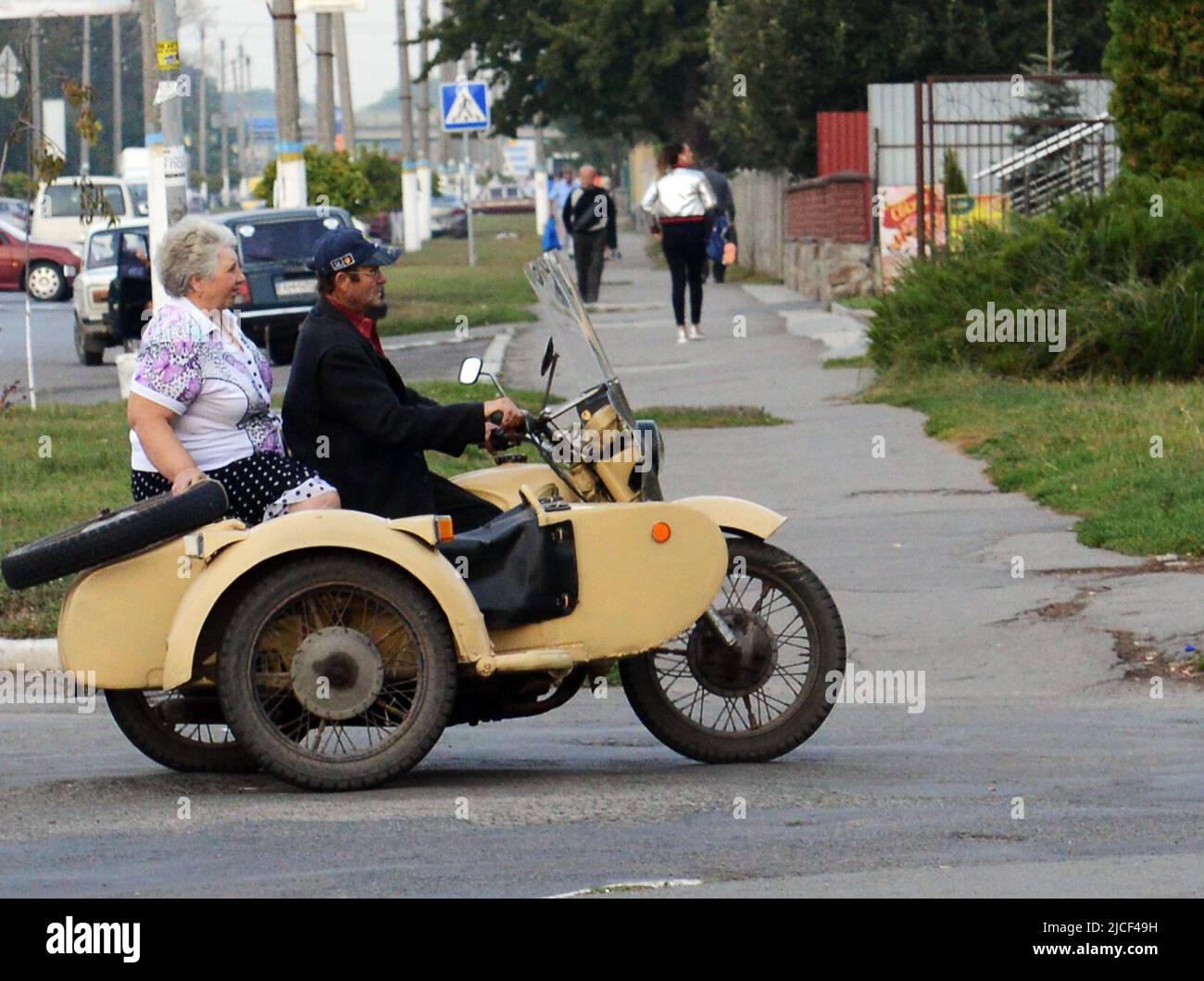 Una pareja ucraniana montando una motocicleta soviética de época con un sidecar en Zashkiv, Ucrania. Foto de stock