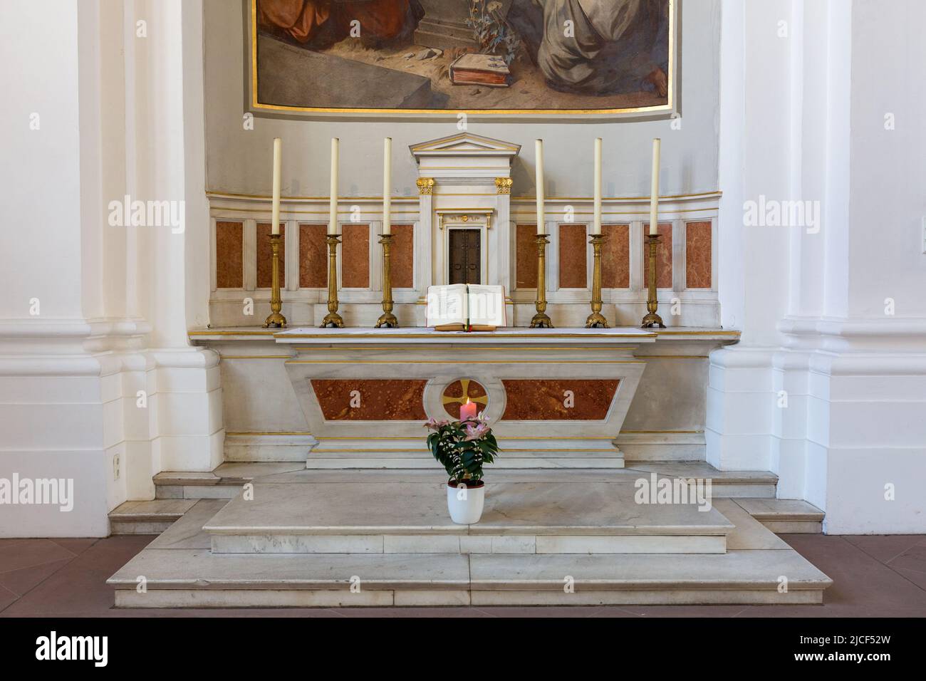 Heidelberg, Alemania - 26 de agosto de 2021: Altar con una biblia abierta y seis velas. Dentro de la iglesia católica de los jesuitas. Foto de stock