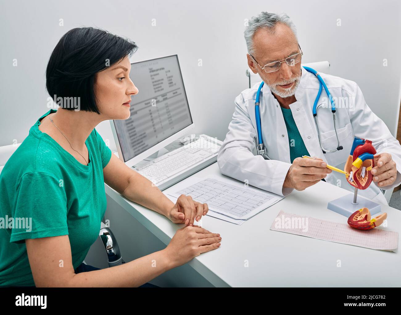 Consulta cardiológica. Médico cardiólogo masculino que consulta a paciente femenino con problemas cardíacos Foto de stock