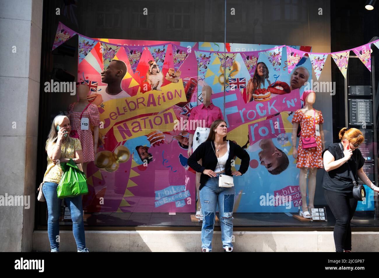 Centro de Londres, Mujeres jóvenes fuera de una tienda de ropa Primark con decoraciones Jubilee. Foto de stock