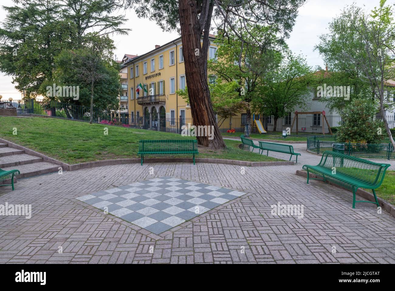 Ayuntamiento (municipio, como está escrito en la fachada), Malnate, Italia. Plaza Vittorio Veneto y pequeños jardines con zona de juegos Foto de stock