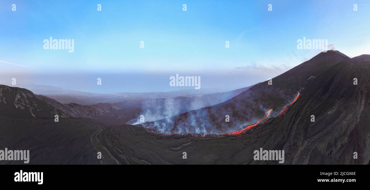Vista de la erupción del flujo de lava del Etna desde arriba - Vista panorámica aérea a la hora azul del atardecer Foto de stock