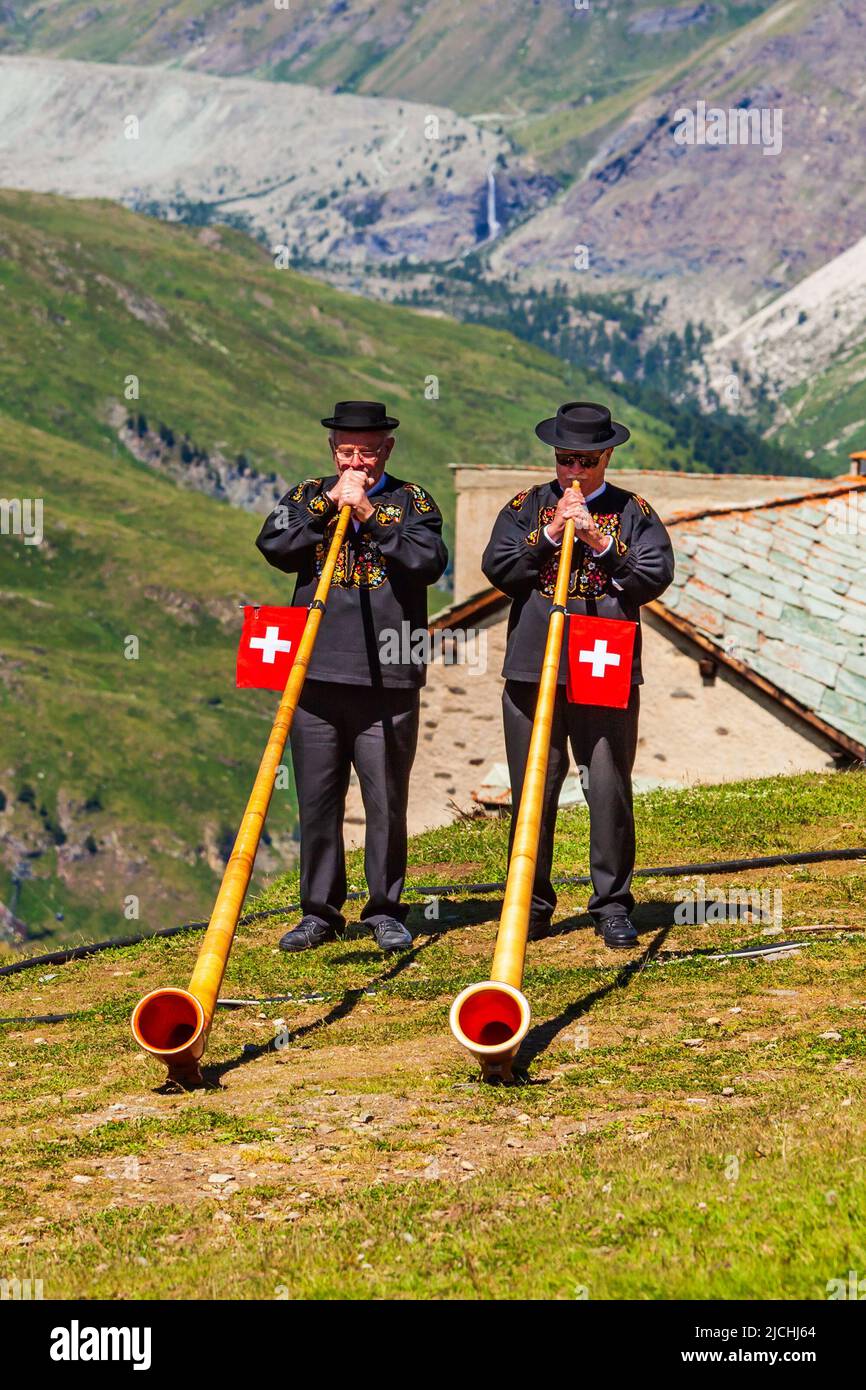 ZERMATT, Suiza - 16 de julio de 2019: Suiza alphorn soplantes están reproduciendo música cerca de la montaña Matterhorn en los Alpes, situado entre Suiza, un Foto de stock