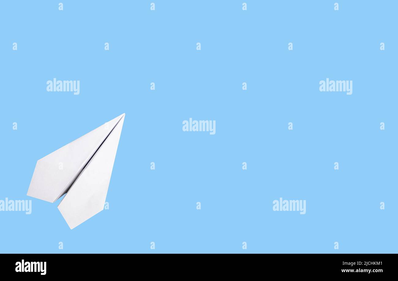 Banner con plano origami blanco sobre fondo azul. Símbolo de arranque por todas partes. Lugar para el texto. Fotografías de alta calidad Foto de stock