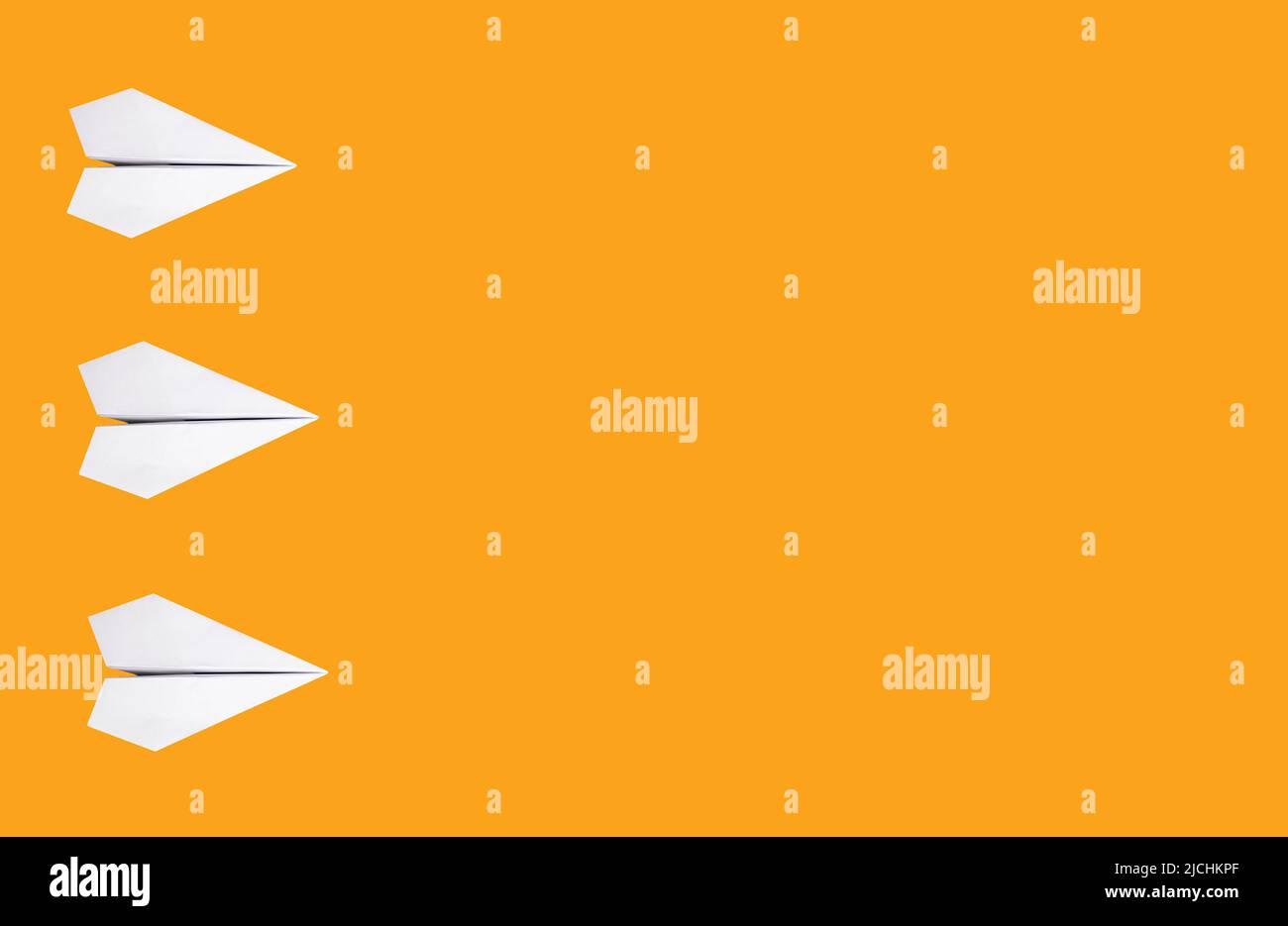 Bandera con planos origami blancos sobre fondo naranja. Plegado de papel. Espacio de copia. Fotografías de alta calidad Foto de stock