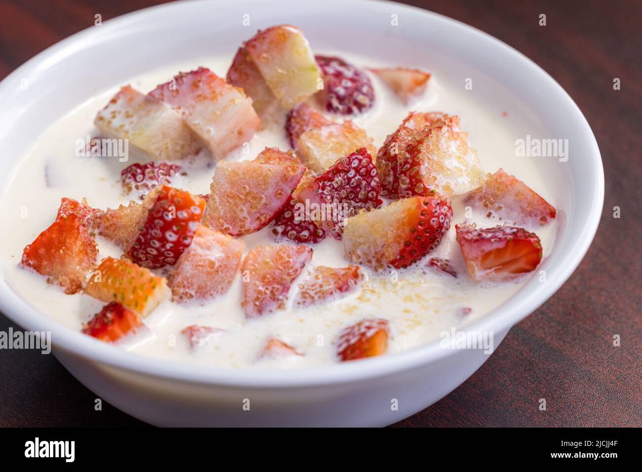 Fresas frescas con crema pesada y una espolvorea de azúcar como aperitivo Foto de stock