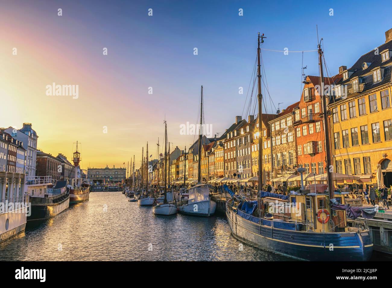 Copenhague Dinamarca, puesta del sol en el horizonte de la ciudad en el puerto de Nyhavn con casa colorida Foto de stock