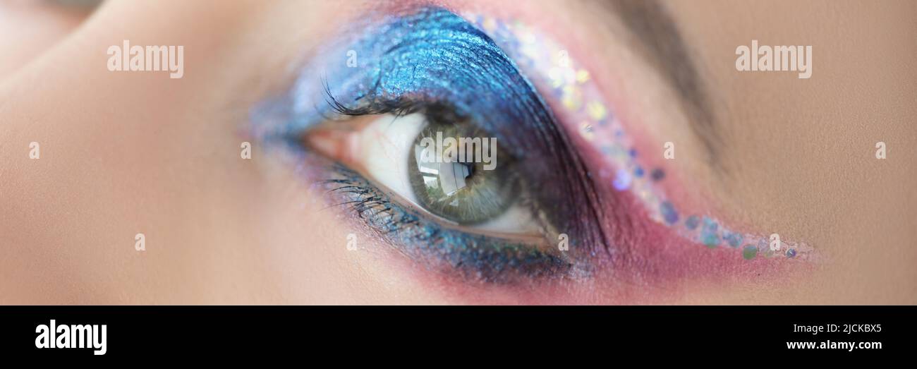  Maquillaje festivo para ojos brillantes en la cara de las mujeres con purpurina azul y rosa Fotografía de stock