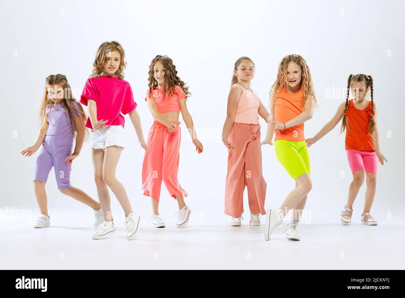 pequeñas felices y deportivas, niños con ropa de colores brillantes bailando danza moderna aislada sobre fondo blanco de estudio. Concepto de música, moda, arte de stock - Alamy