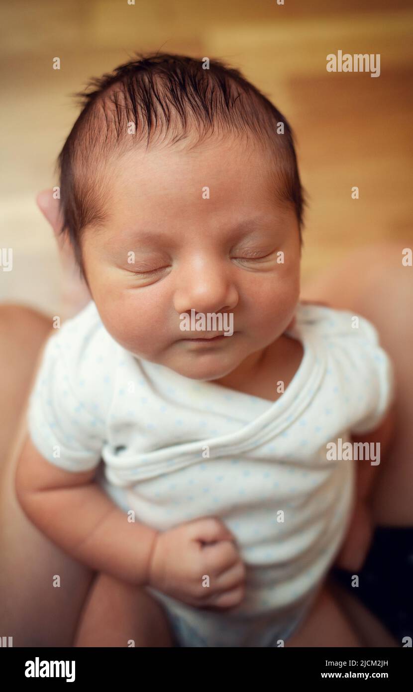 Primer plano de un recién nacido de pocos días de edad con ojos cerrados. Concéntrese en la cabeza y, a continuación, en los detalles del pelo, los ojos y la nariz. Foto de stock