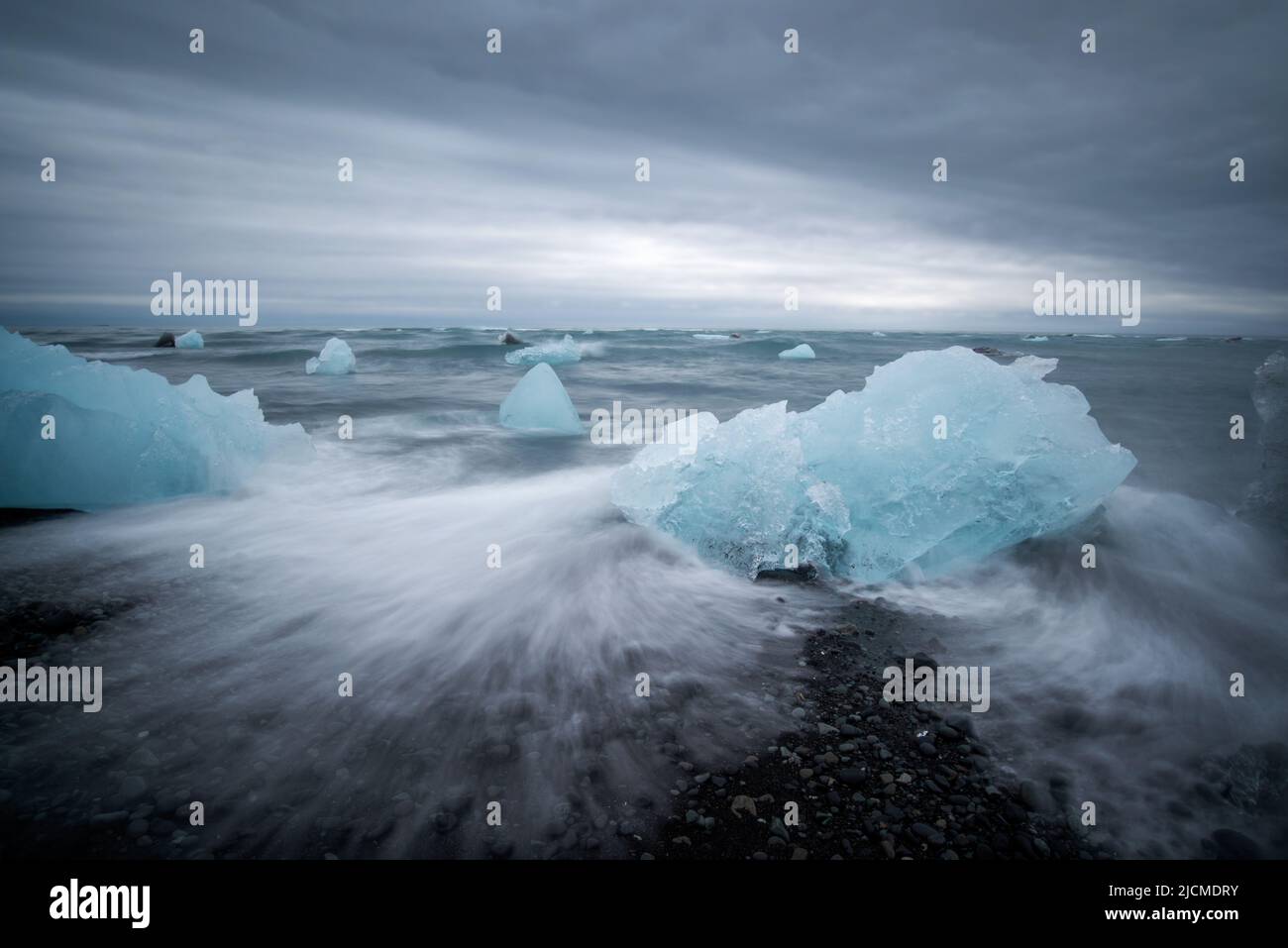 Icebergs y arena negra en Jokulsarson Diamond Beach, Islandia Foto de stock