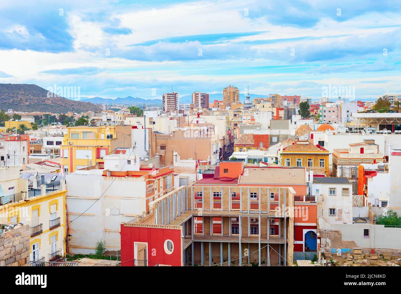 Paisaje urbano de Cartagena, coloridas casas y montañas en el fondo, España Foto de stock