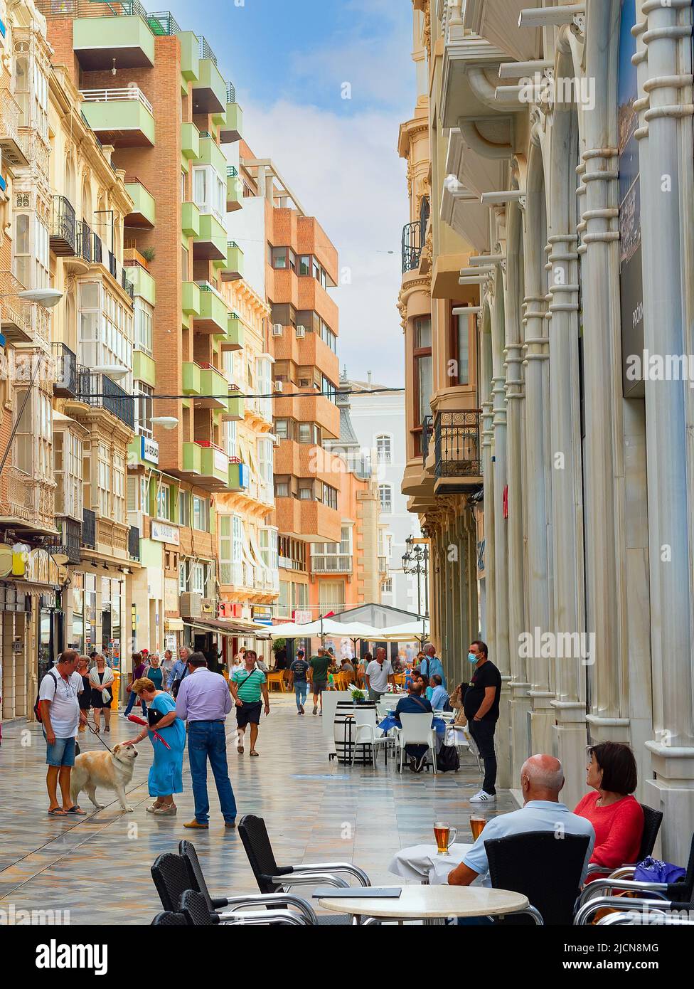 CARTAGENA, ESPAÑA - 1 DE NOVIEMBRE de 2021: Concurrida calle de la ciudad comercial con cafés, gente que camina, arquitectura moderna Foto de stock