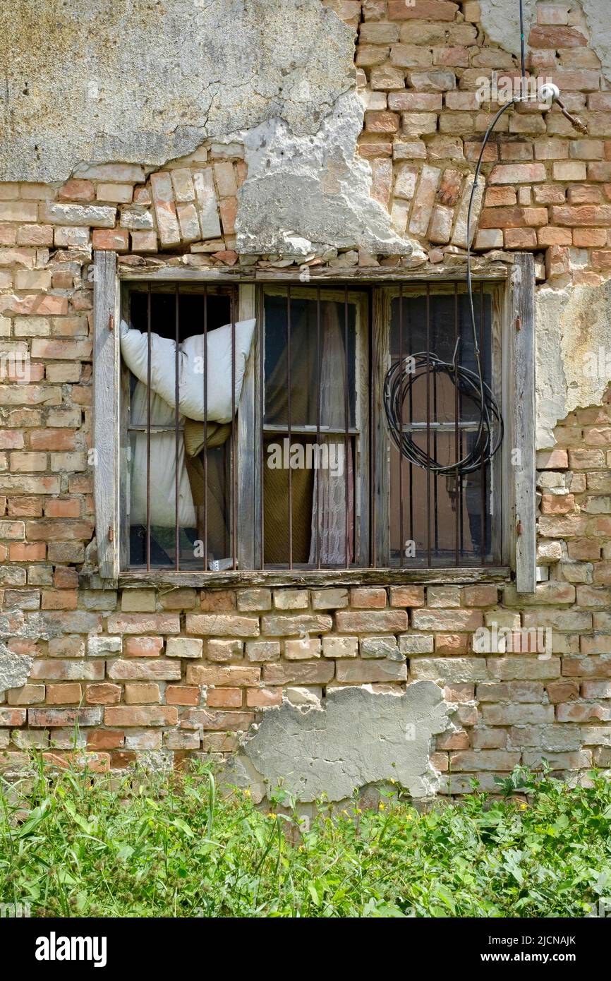 marco de ventana de madera podrida con cristal perdido en la pared de una casa descuidada desmoronándose en necesidad de renovaciones lenti zala condado de hungría Foto de stock