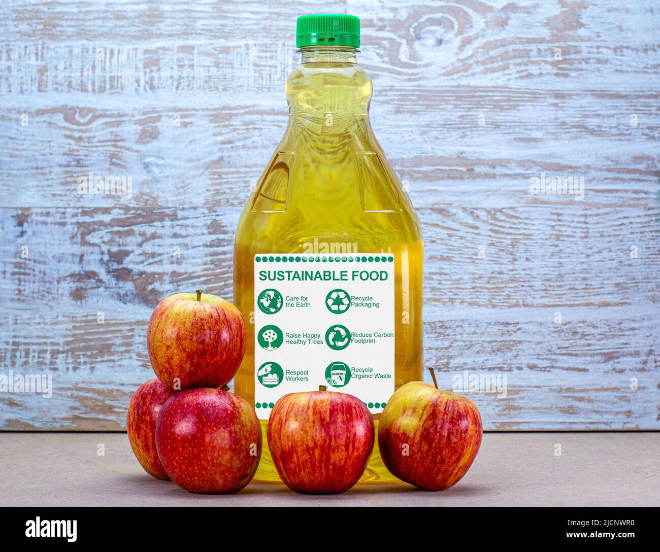 alimentos sostenibles, etiquetas éticas de alimentos ecológicos en botella de jugo de manzana, respetar a los trabajadores, reciclar, reducir los residuos Foto de stock