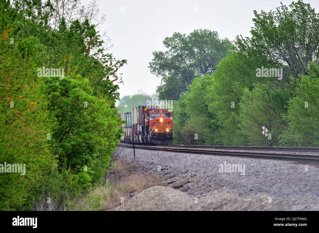 Niota, Illinois, Estados Unidos. Un tren de carga intermodal Burlington Northern Santa Fe, que va al oeste y va a ser regado por un par de locomotoras, espera una señal verde. Foto de stock
