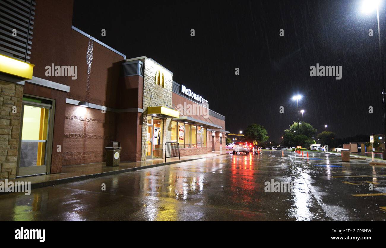 Los coches esperan en cola en un McDonald's en una noche lluviosa en Irving, Texas Foto de stock
