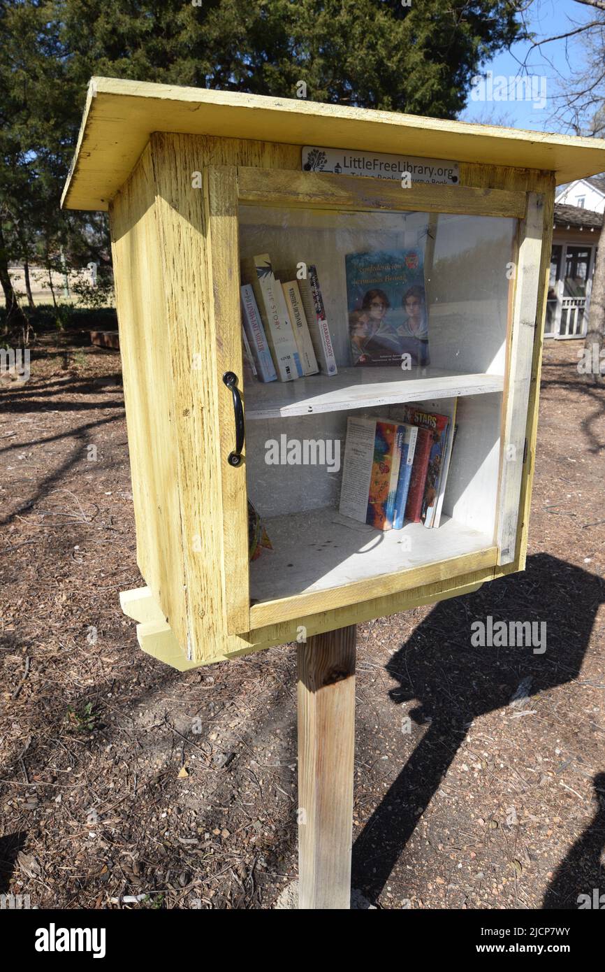 Una pequeña caja de biblioteca gratuita llena de libros gratuitos en un parque de la ciudad Foto de stock