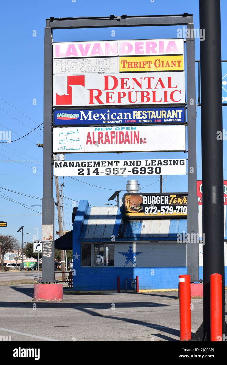 Letreros en un centro comercial en Irving Texas anunciando una Lavanderia, una tienda de treinta pies, la República Dental y otras tiendas Foto de stock