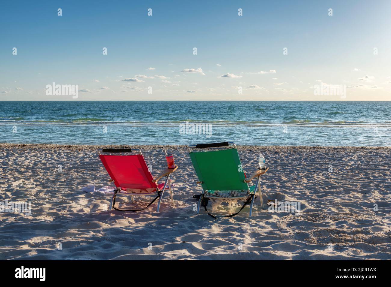 Vistas al atardecer de tumbonas de playa con accesorios de playa en Naples Beach, Florida, Estados Unidos Foto de stock