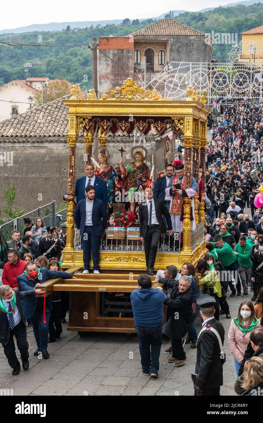 Estatuas de los tres santos patronos locales que son arrastrados en procesión por las empinadas calles del pueblo de Sant'Alfio, Sicilia, Italia, en mayo Foto de stock