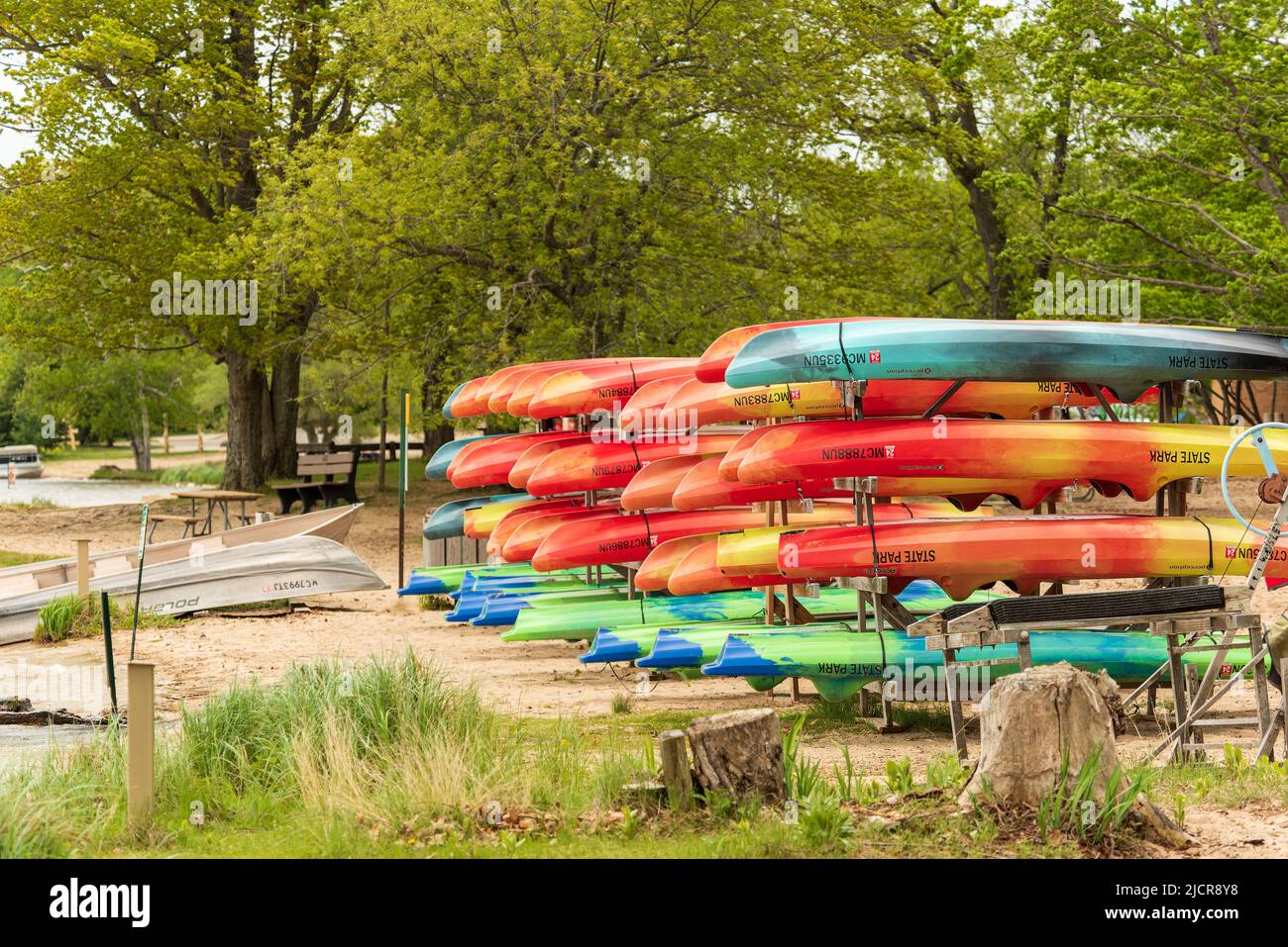 Ludington, MI - 21 de mayo de 2022: Coloridos kayaks de alquiler almacenados en una playa Foto de stock