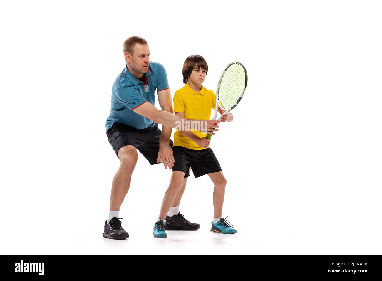 Formación. Jugador profesional de tenis, entrenador enseña a los  adolescentes a jugar al tenis aislado sobre fondo blanco de estudio.  Concepto de deporte, logros, hobby Fotografía de stock - Alamy