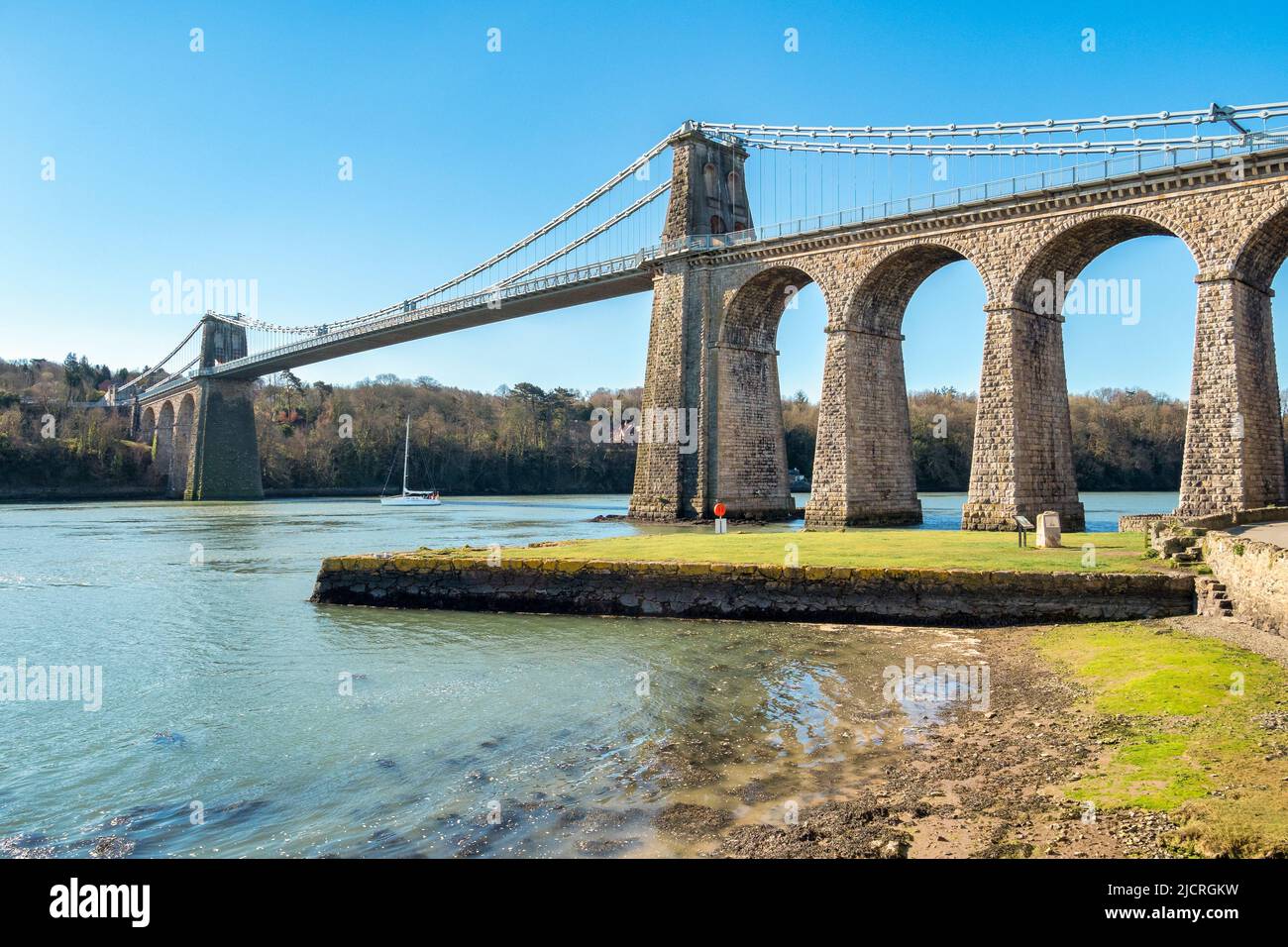 Puente Menai, cruzando el estrecho de Menai, diseñado por Thomas Telford, Anglesey, Gales, Reino Unido Foto de stock