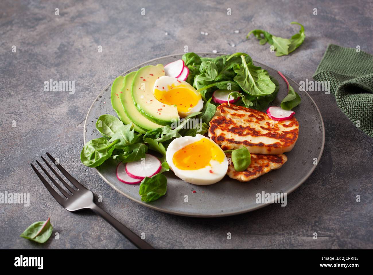 Ceto paleo dieta saludable Desayuno: huevos, aguacate, queso halloumi, ensalada de hojas Foto de stock