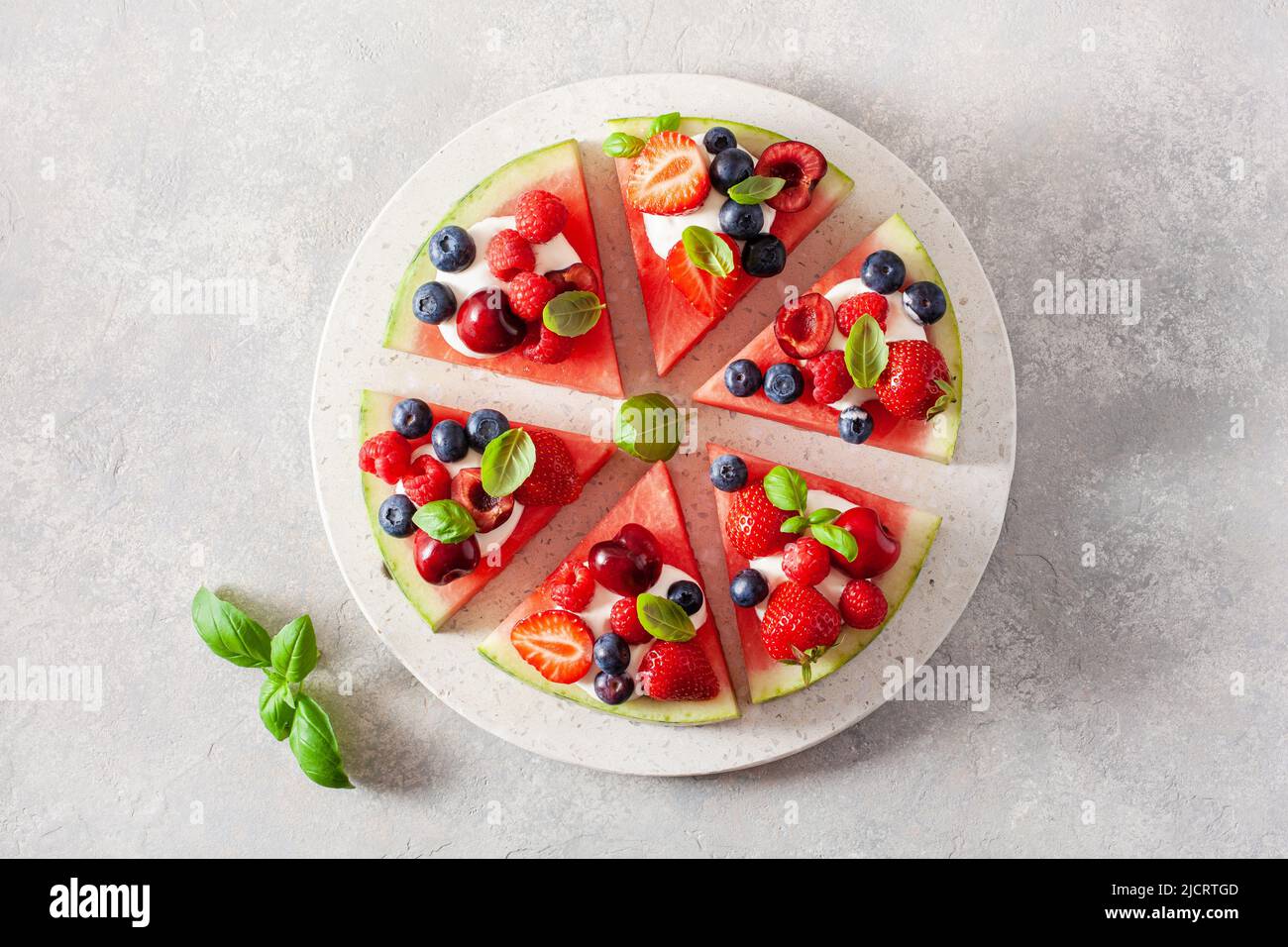 Porciones de pizza de sandía con yogur y bayas, postre de verano Foto de stock