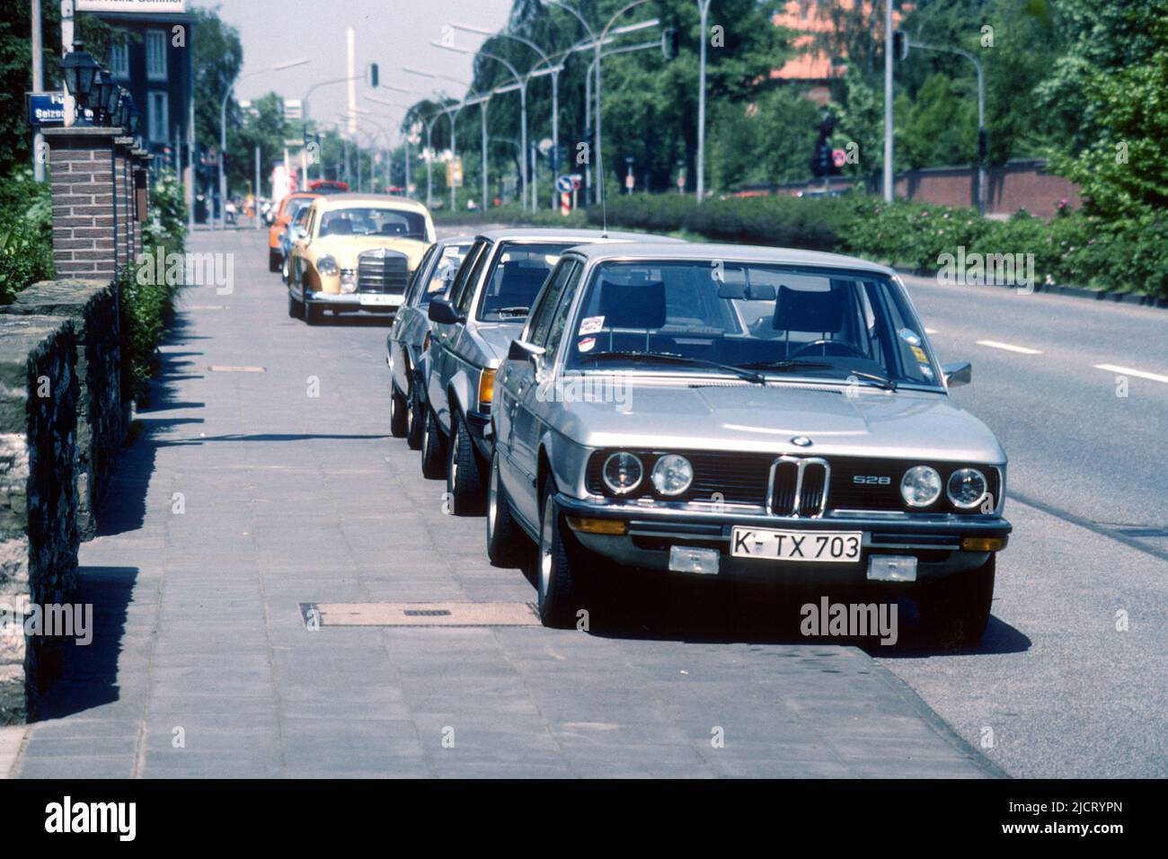 BMW 528 y otros coches estacionados en el pavimento de la calle en 1982, Colonia, Renania del Norte-Westfalia, Alemania Foto de stock