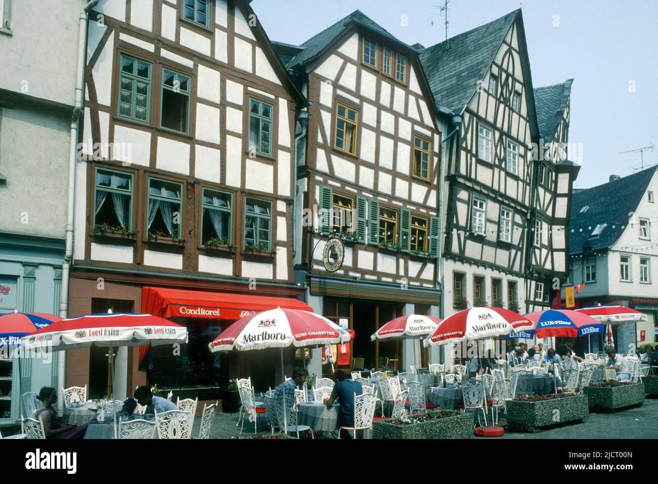 Casas antiguas y mesas de café en el centro de la ciudad en 1982, Limburgo, Hessen, Alemania Foto de stock