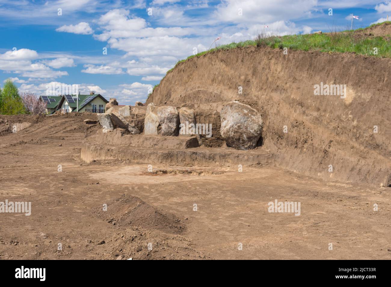 Paisaje primaveral con excavaciones Lugar de placas de lápida de granito en el antiguo montículo funerario en Novooleksandrivka pueblo en Ucrania de alrededor de 1200s Foto de stock