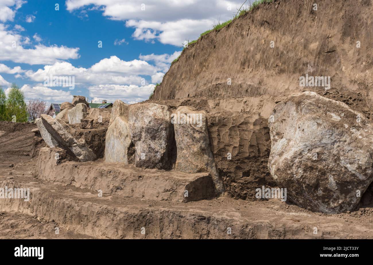 Paisaje con excavaciones Lugar de placas de lápida de granito en el antiguo montículo funerario en Novooleksandrivka pueblo en el centro de Ucrania de alrededor de 1200 Foto de stock