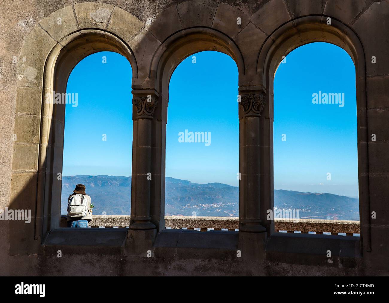 Ventana al aire libre con una persona en Montserrat. El Girl Traveler disfruta de las vistas panorámicas de Cataluña. Foto de stock