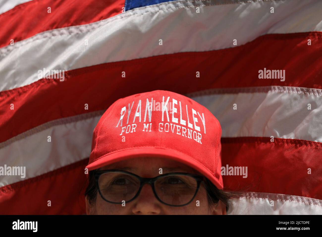 Un partidario del candidato republicano de Michigan a la gobernación Ryan Kelley tiene una bandera estadounidense mientras escucha a un orador durante un evento de Marcha por la Libertad Médica organizado por Informed Choice Michigan en Lansing, Michigan, EE.UU., 15 de junio de 2022. REUTERS/Emily Elconin Foto de stock