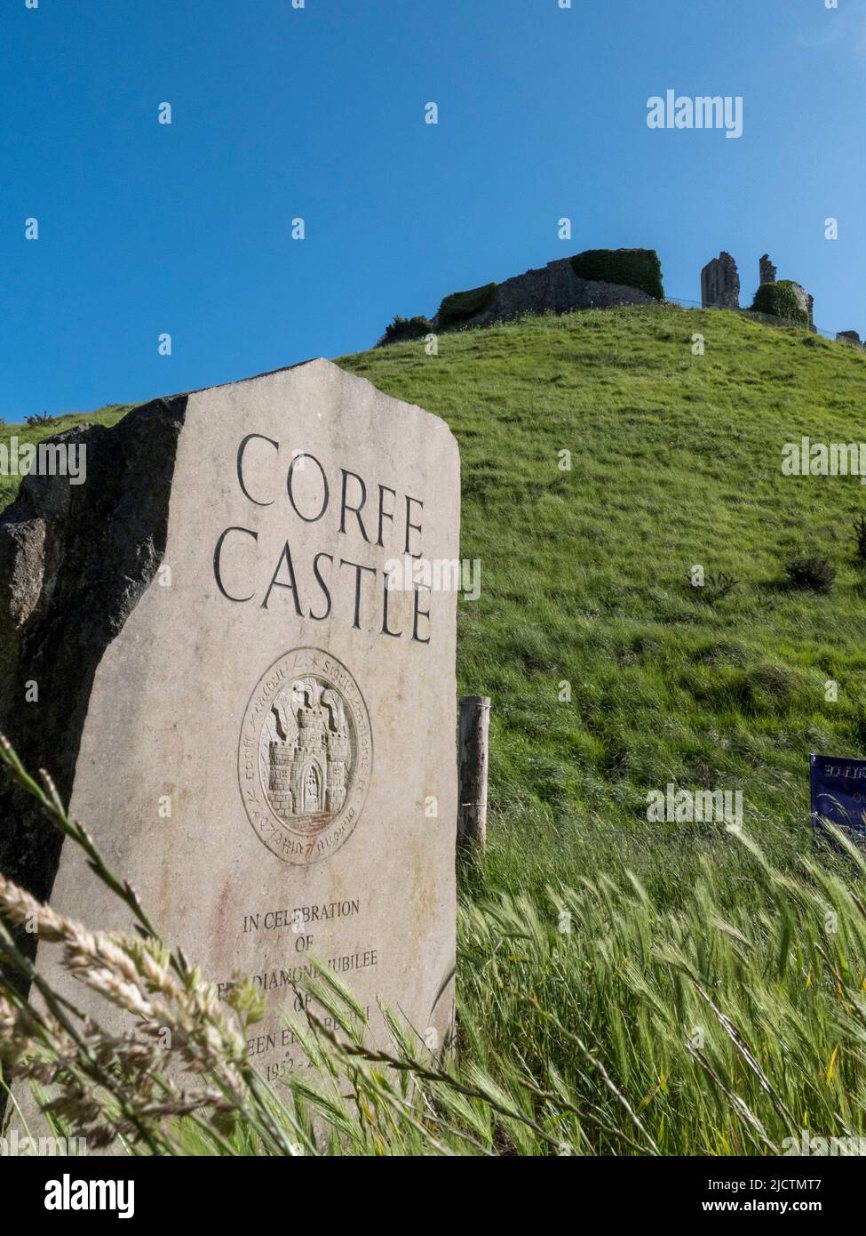 Marcador de piedra para el castillo de Corfe, Dorset, Reino Unido con el castillo en el fondo. Foto de stock